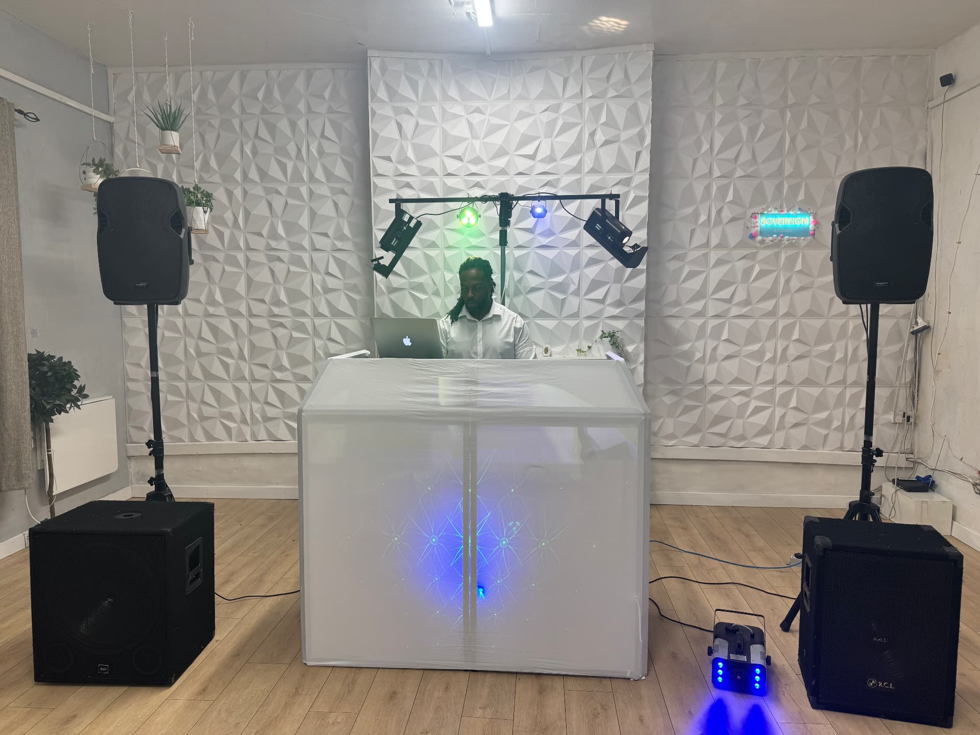 Full white DJ booth setup with speakers, subs and lighting